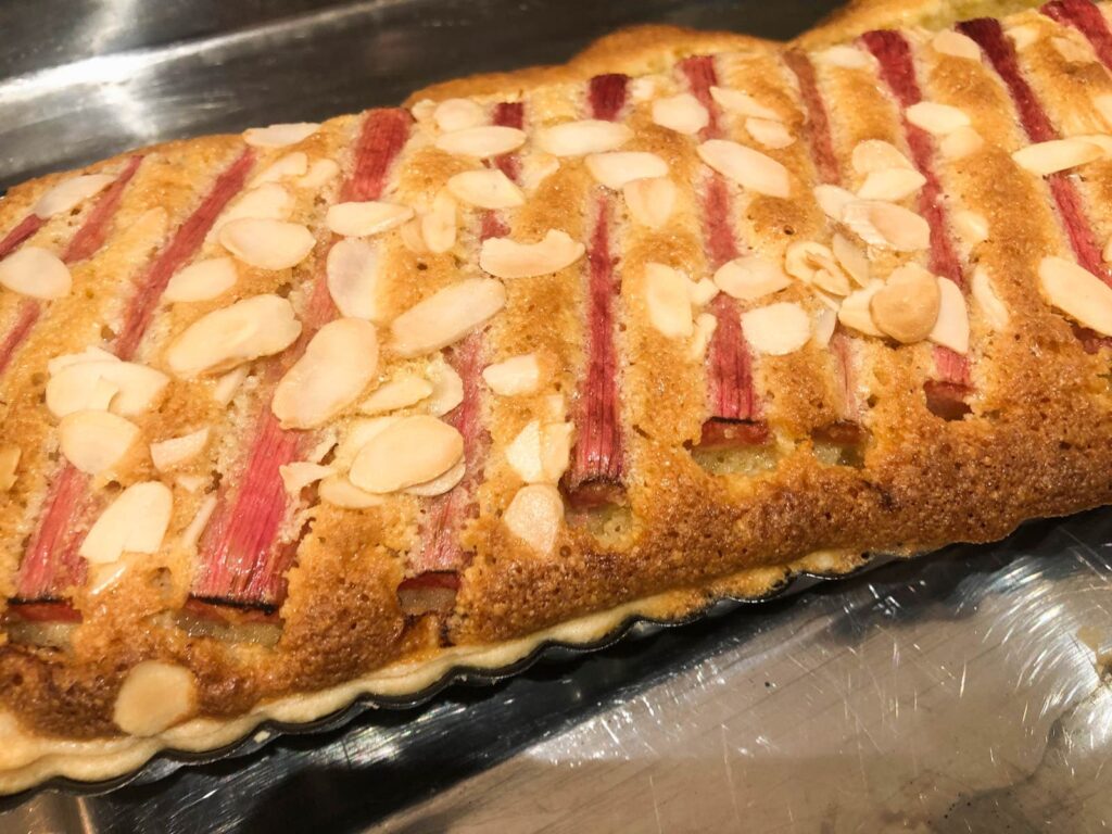 An oblong tart fresh of from the oven of rhubarb and frangipane.