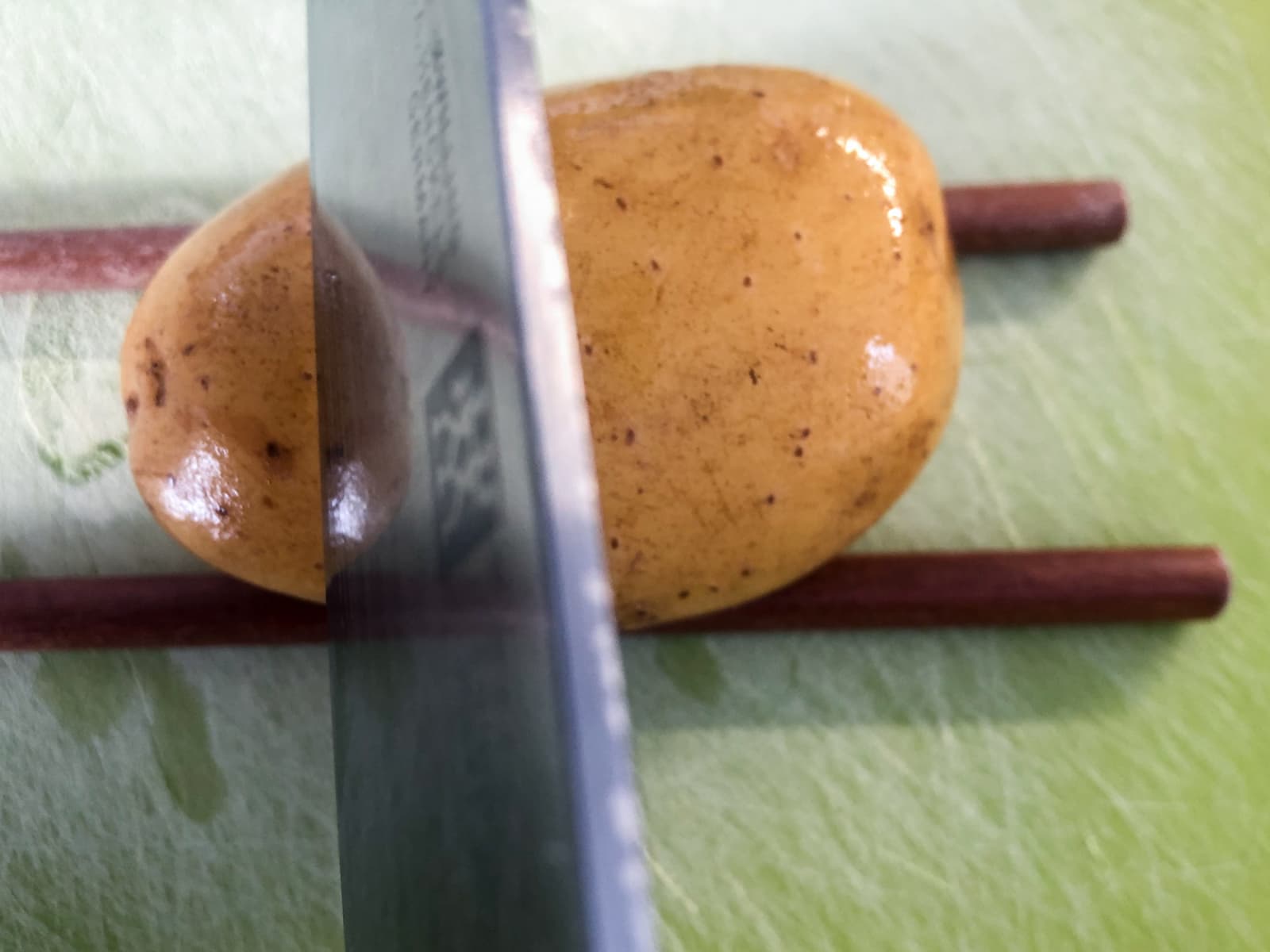 Using 2 chopsticks to stop a knife from cutting all the way through potatoes
