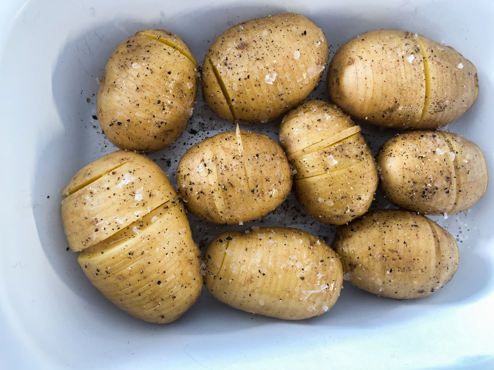 Potatoes sliced and seasoned with salt and pepper ready for the oven.