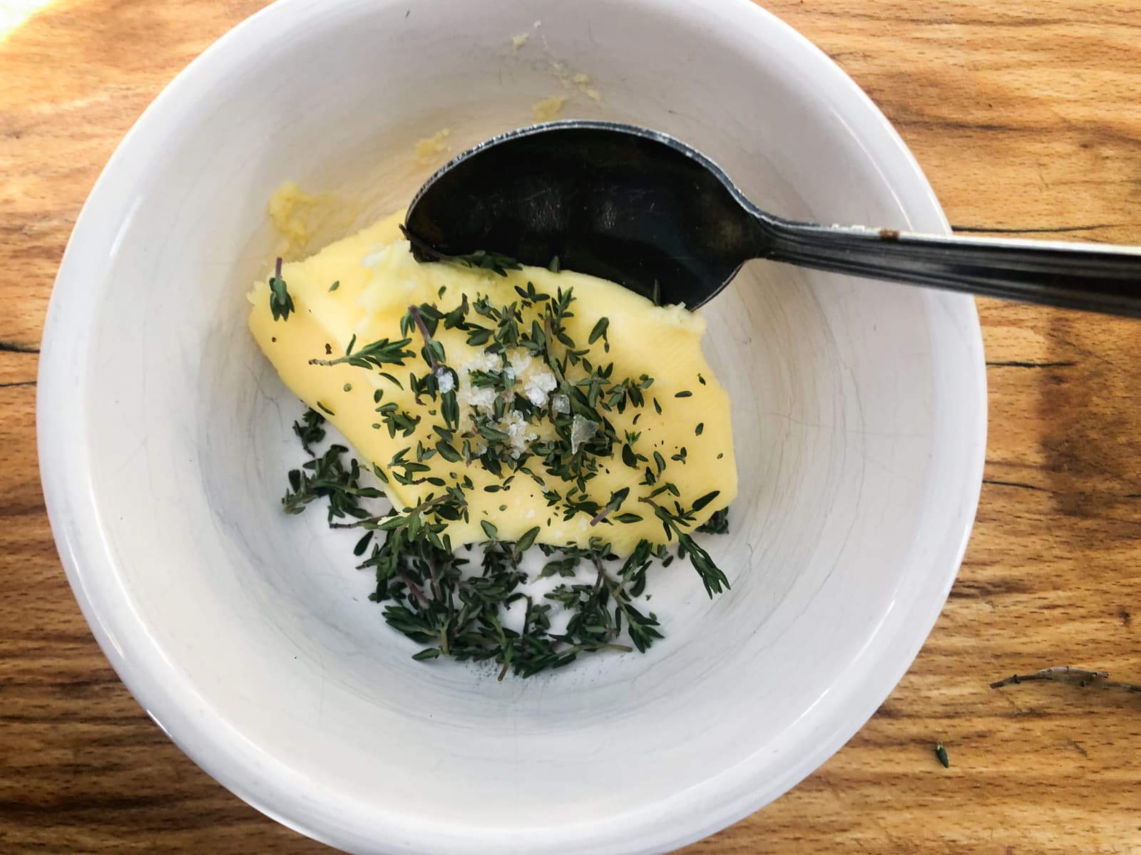 A dish of butter with added salt and fresh thyme