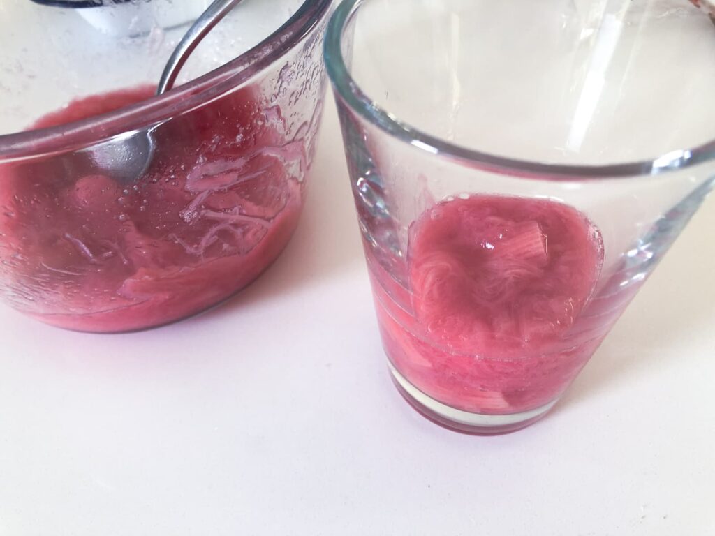 Glasses with poached rhubarb layered in the bottom