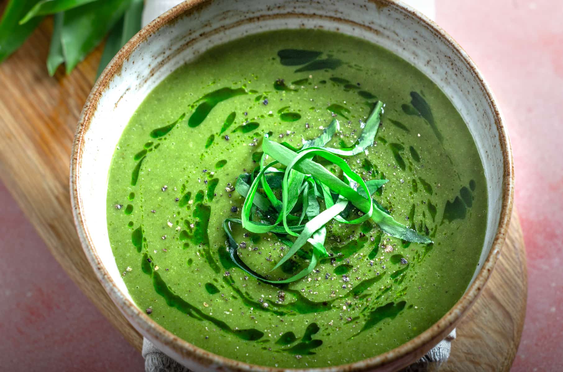 Wild garlic soup drizzled with wild garlic oil and topped with shredded wild garlic leaves.