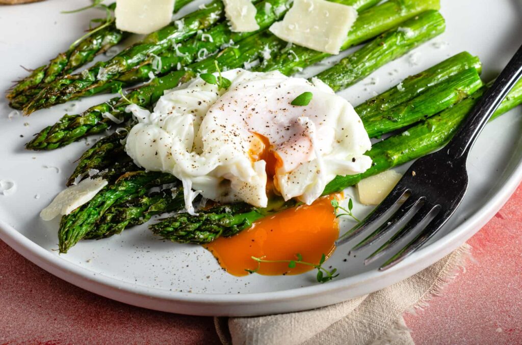 Oven roasted asparagus topped with shavings of parmesan cheese and a runny poached egg.