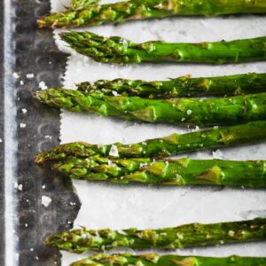 Roasted asparagus spears topped with seat salt.