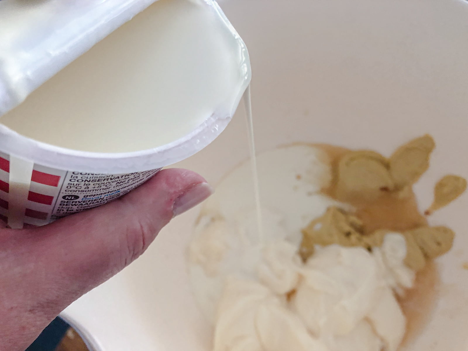 Pouring double cream into a bowl.