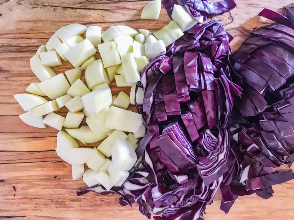 Chopped apple and red cabbage on a board.