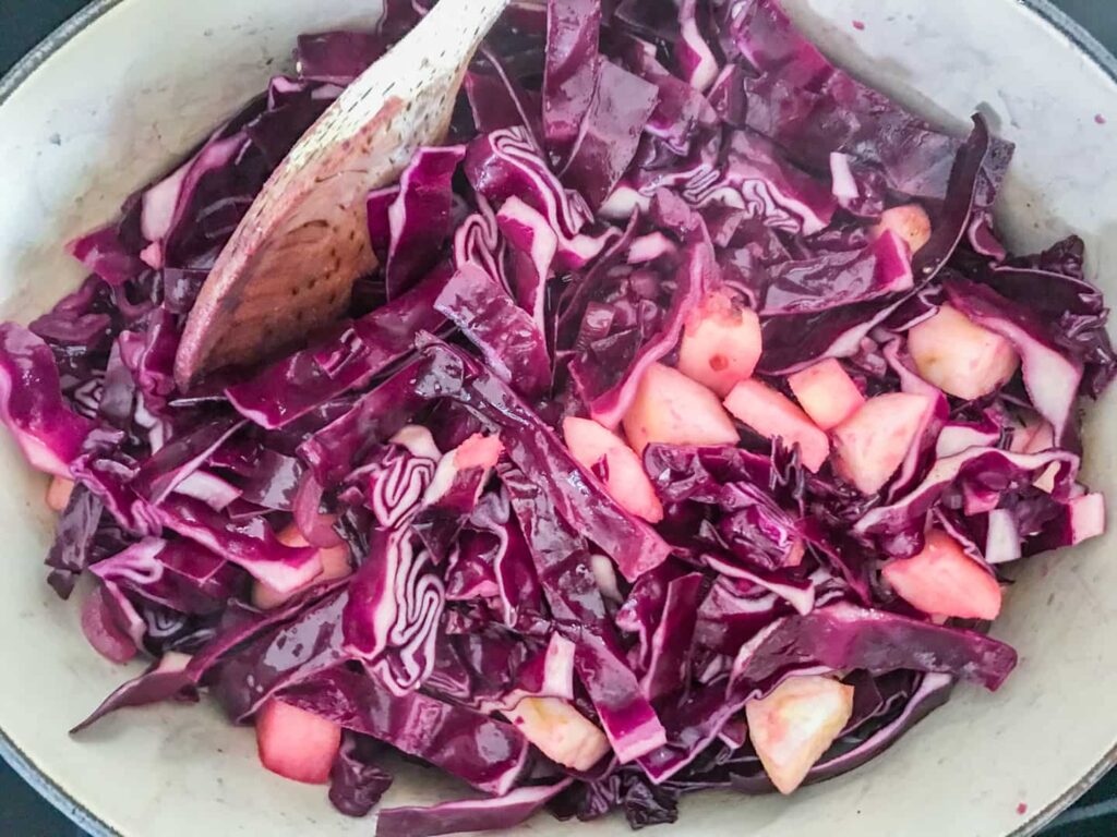 Red cabbage slowly cooking in a cast iron pan.