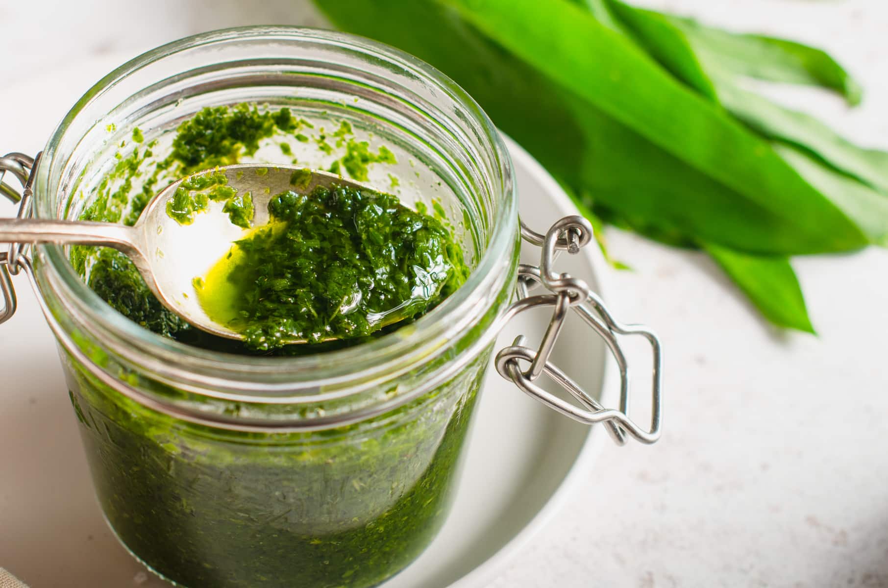 A jar of vibrant green wild garlic chimichurri sauce