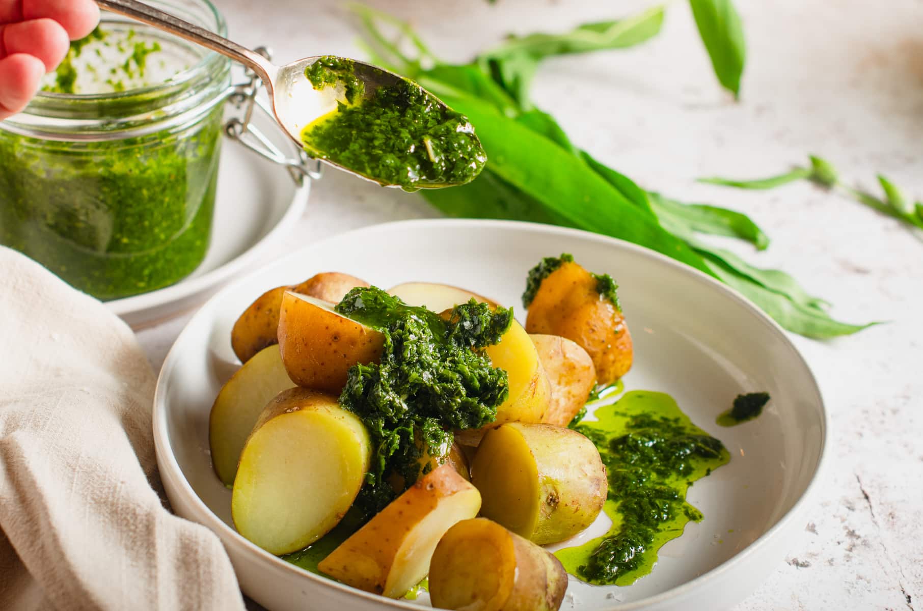 A serving suggestion of wild garlic chimichurri over top of fresh boiled potatoes.