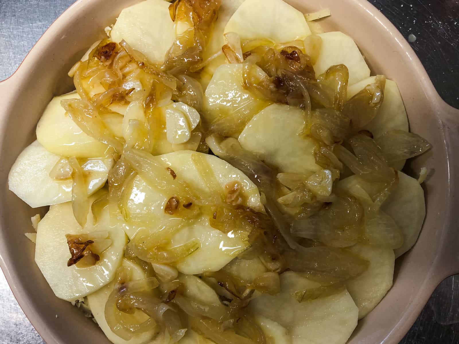 Lightly caramelised onions over tope of sliced potatoes and grated cheese.