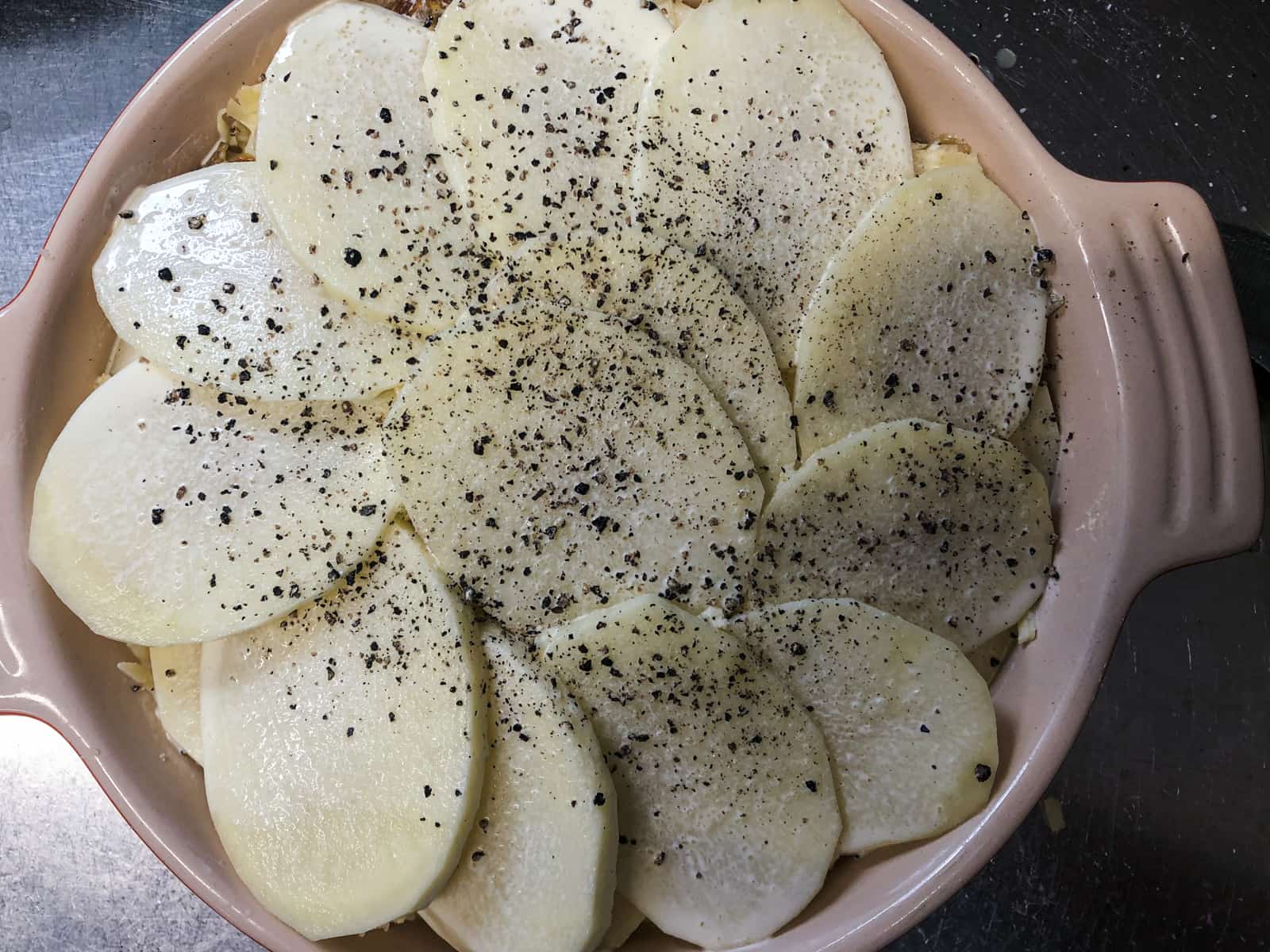A spiral layer of potatoes to finish off a gratin bake, before being put into the oven.