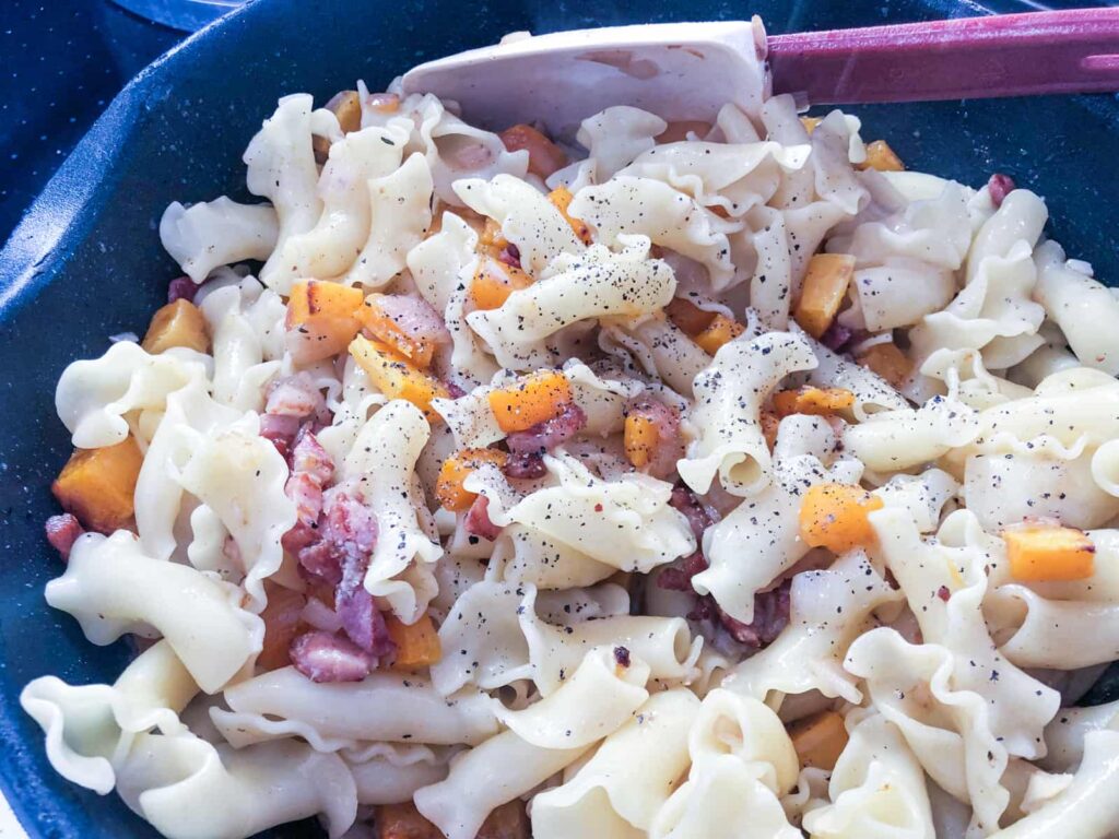 Curly pasta shapes added to squash, bacon and browned butter sauce.