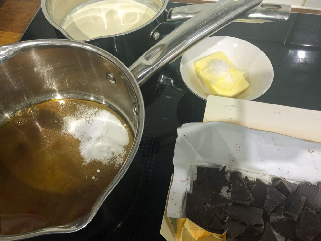 Ingredients for making chocolate mousse, dark chocolate, butter, salt, dark sugar, cream and eggs.