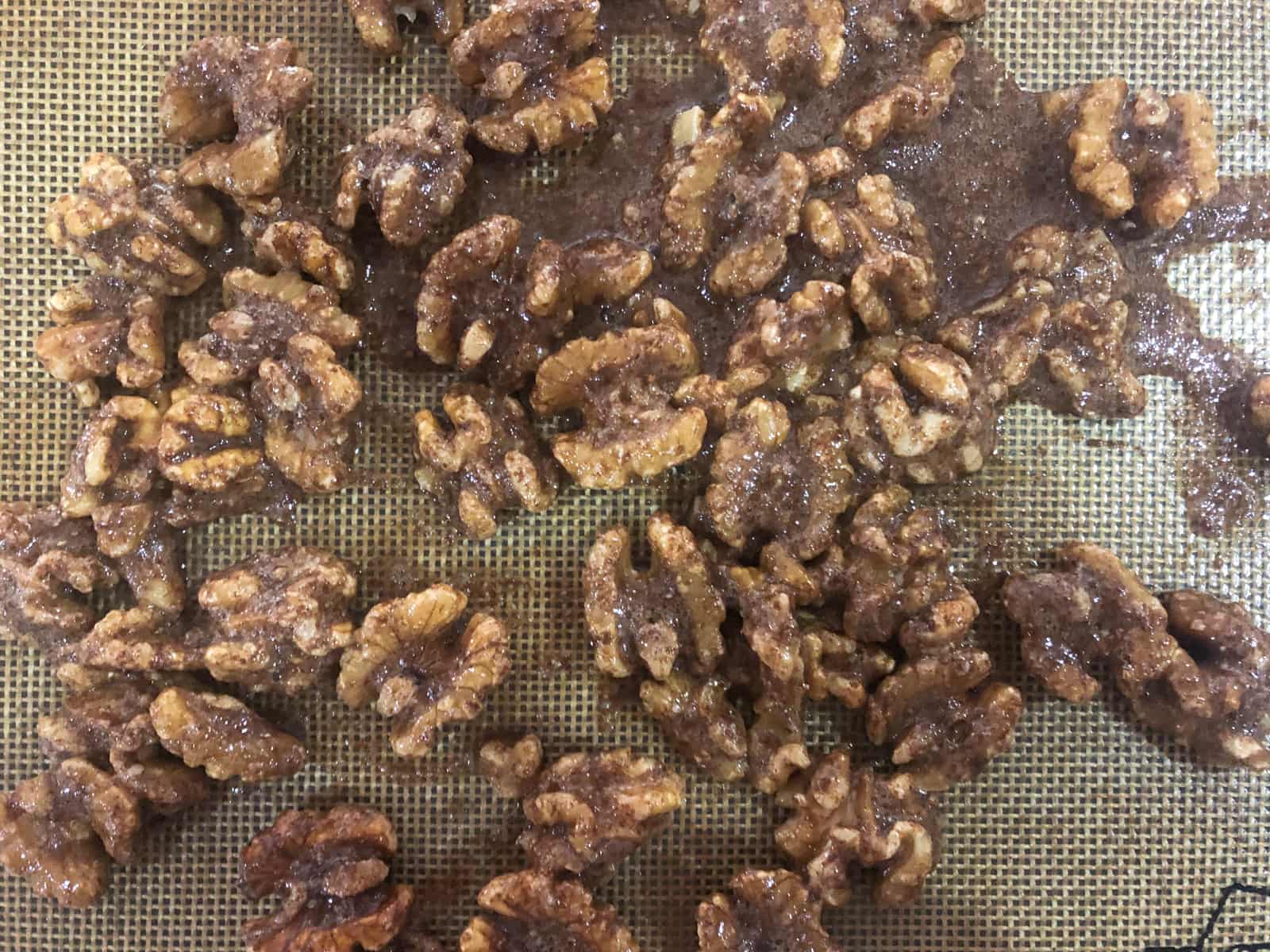 Spiced walnuts cooling on a silpat mat.