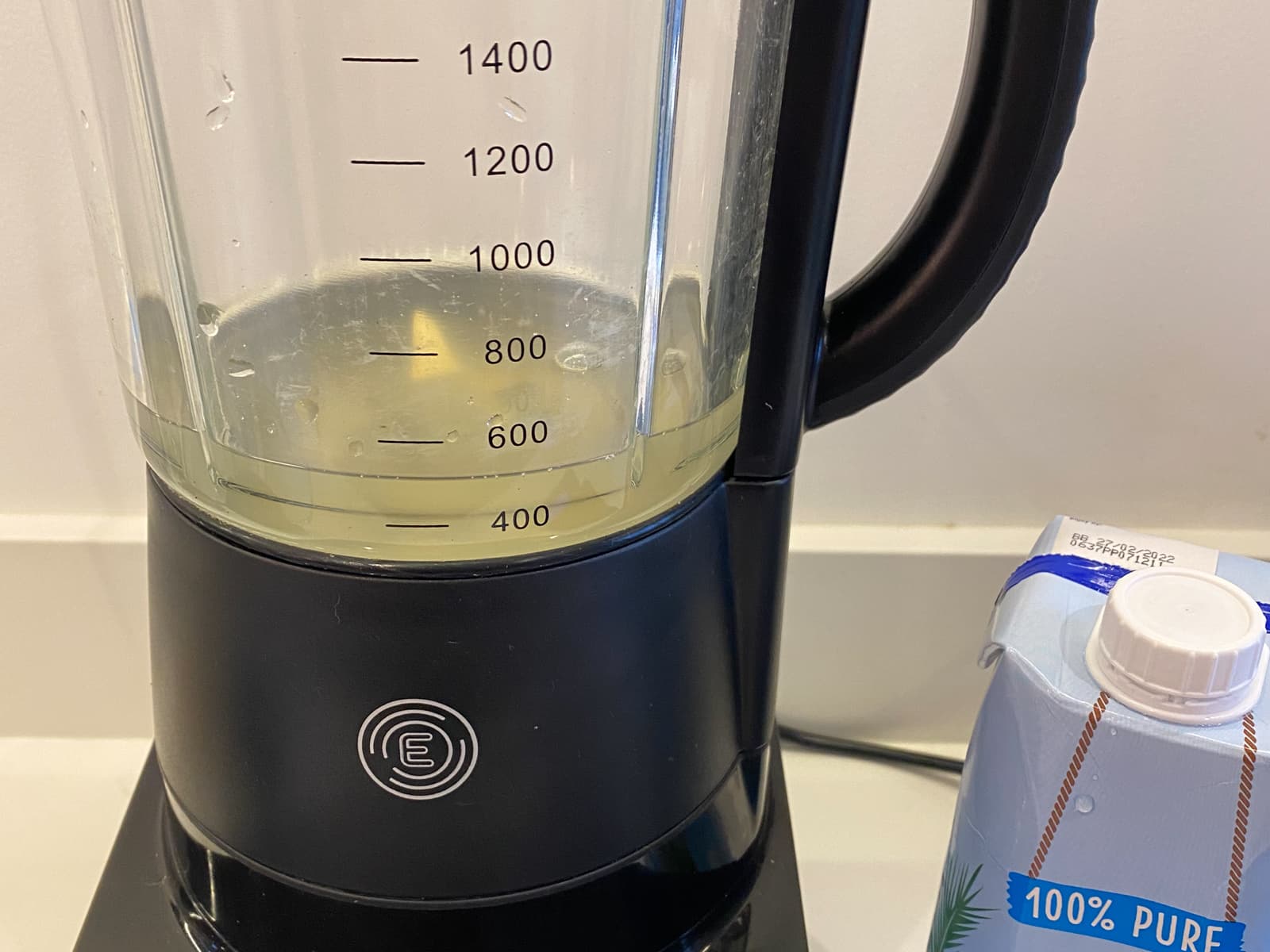 Coconut water measured into a blender to begin making a smoothie.