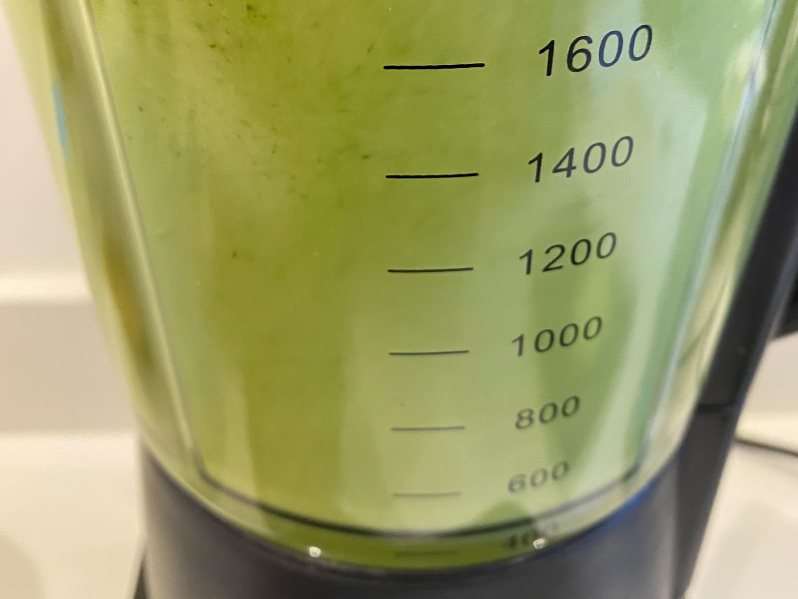 A green smoothie blending in a high speed blender.