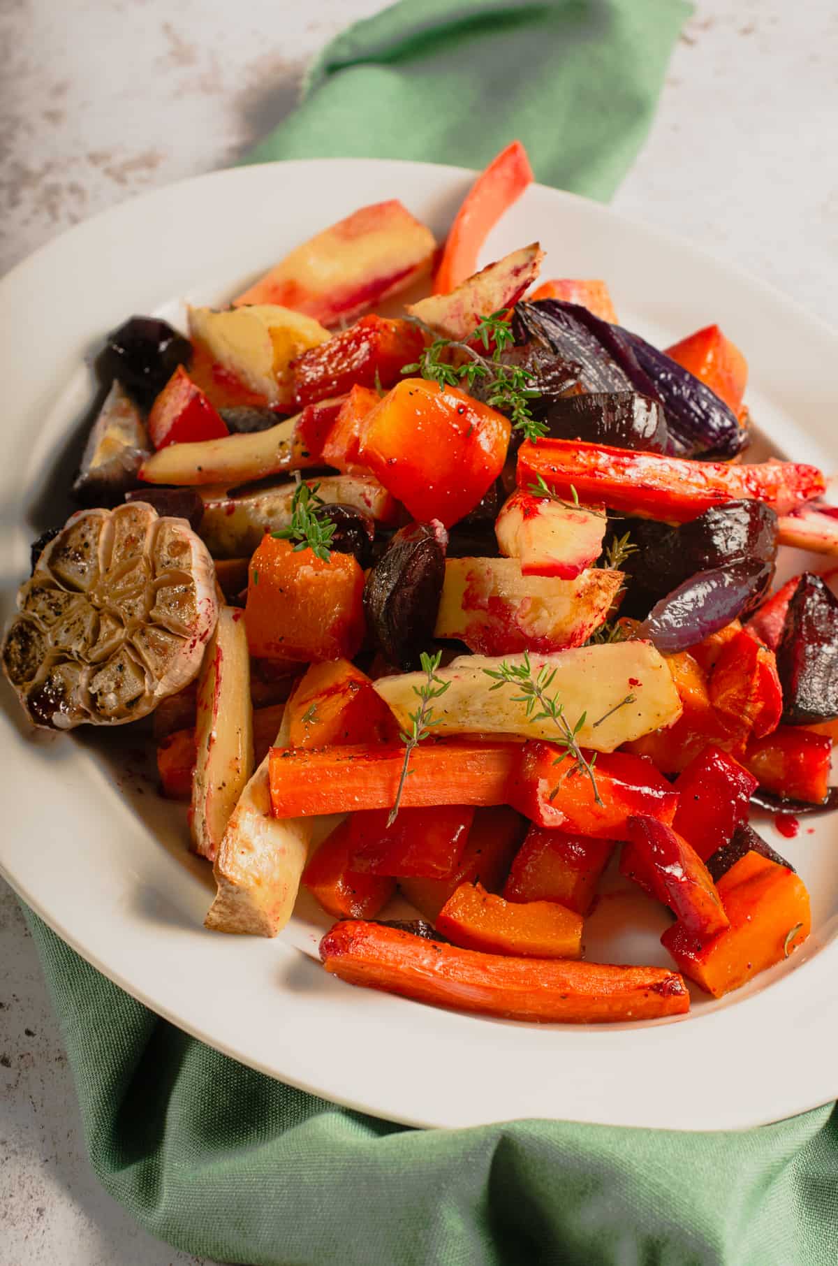 A platter filled with honey roasted vegetables and garlic.