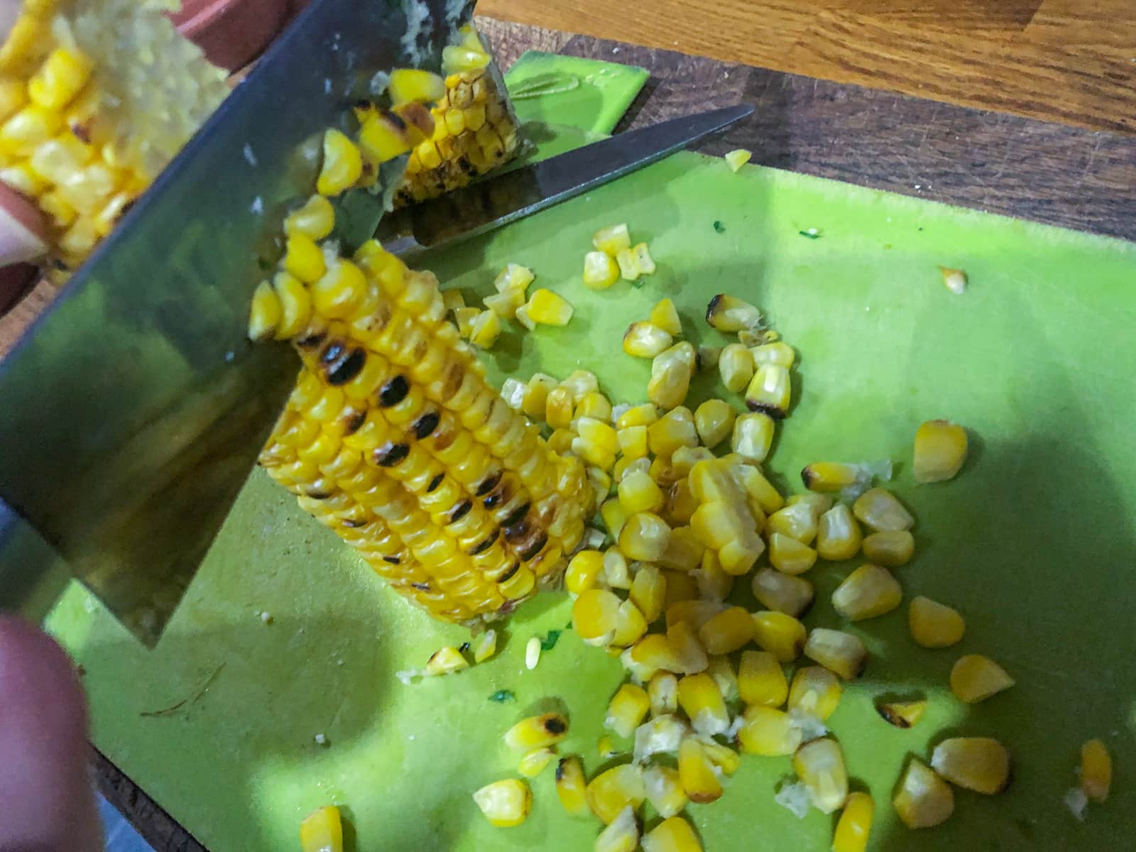 Slicing charred corn kernels from the cob.