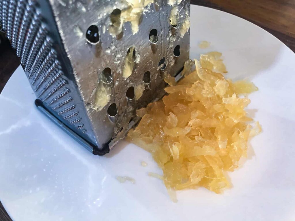 Grated crytalised ginger on a white plate.