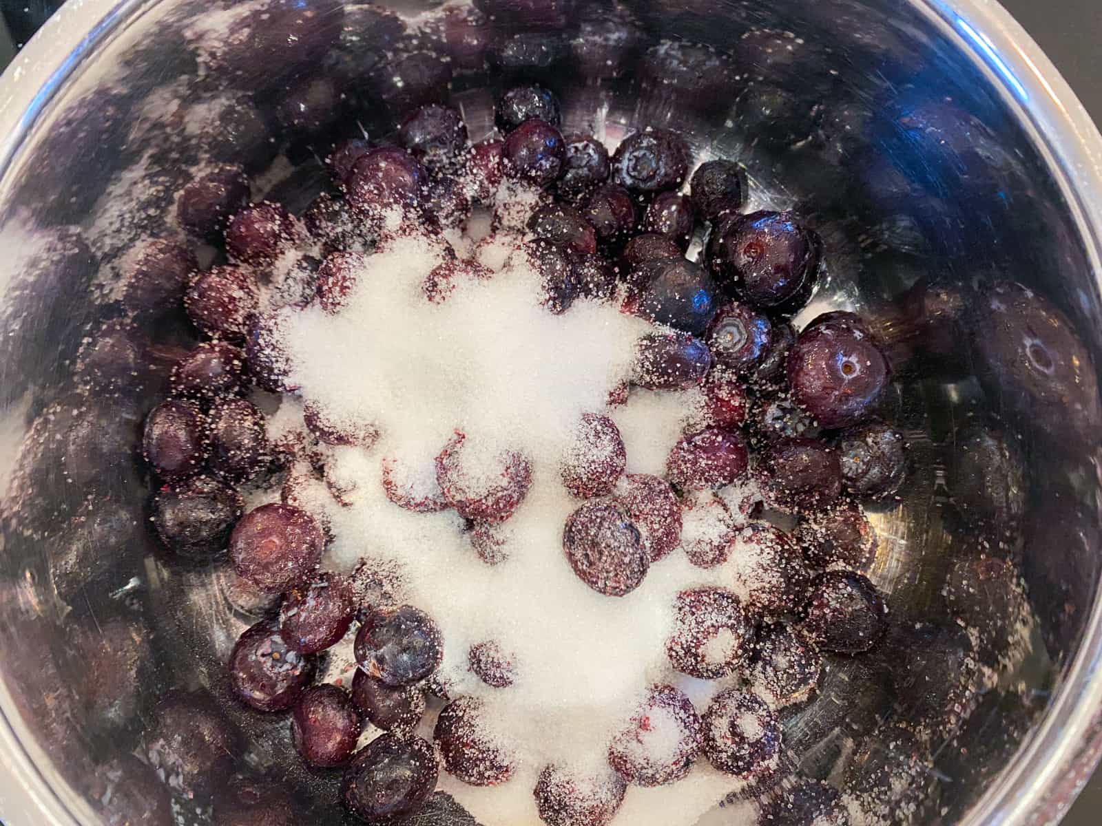 Frozen blueberries and sugar in a small pan to make a compote.