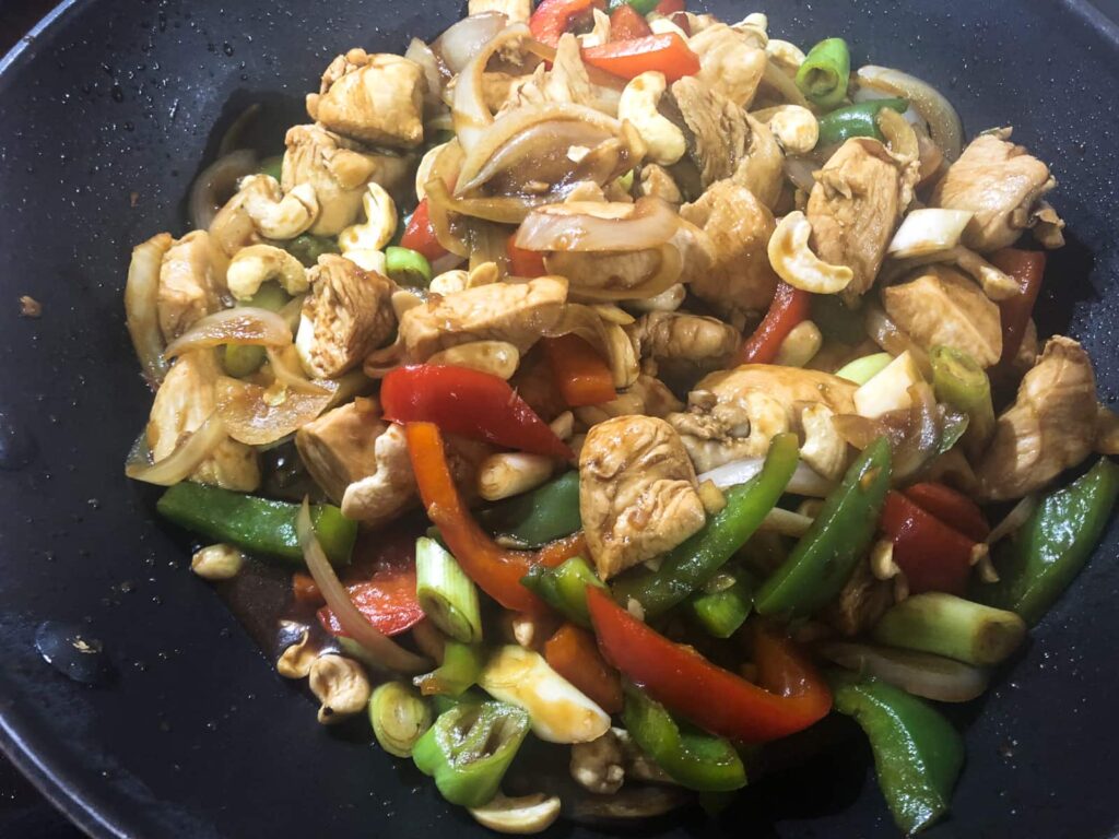 Chicken stirfry with peppers and cashews in the final stages of cooking.