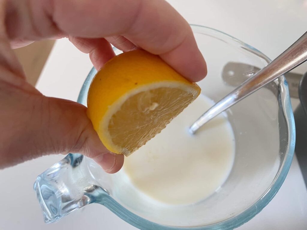 Making buttermilk by adding lemon juice to milk to sour it.