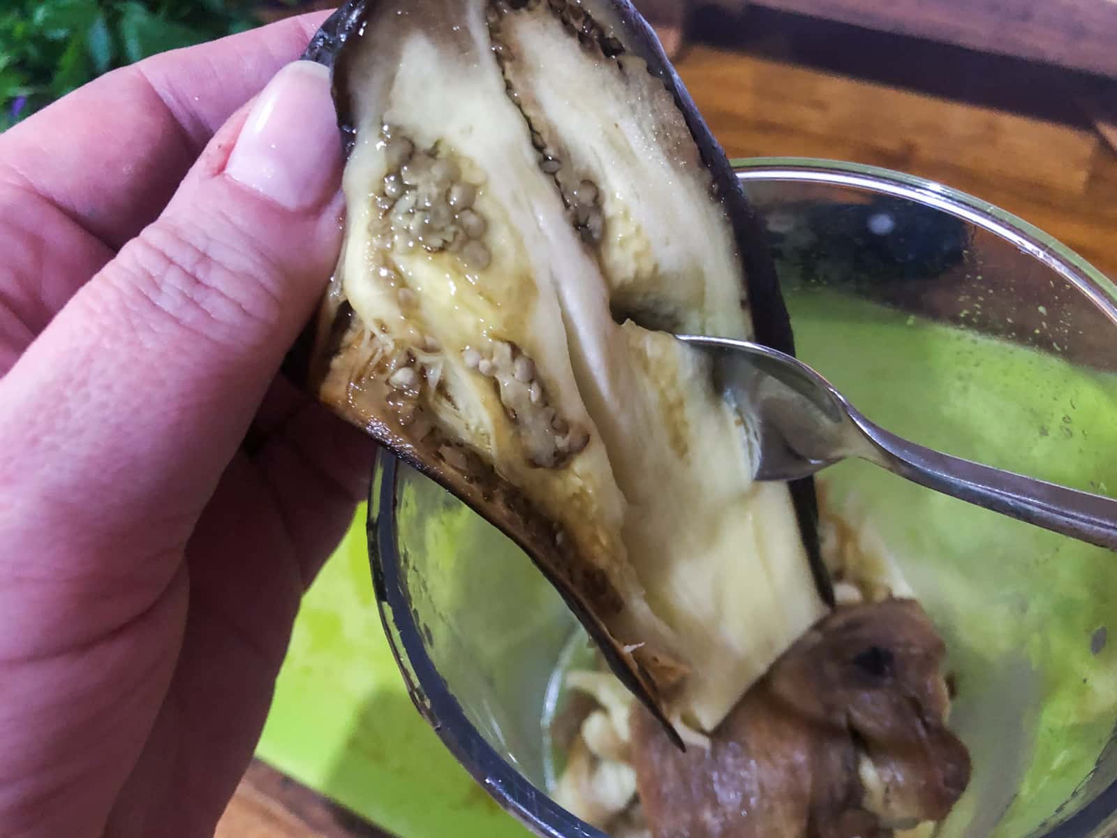 Removing the baked inside pulp from a cooked aubergine (eggplant) to make a dip.