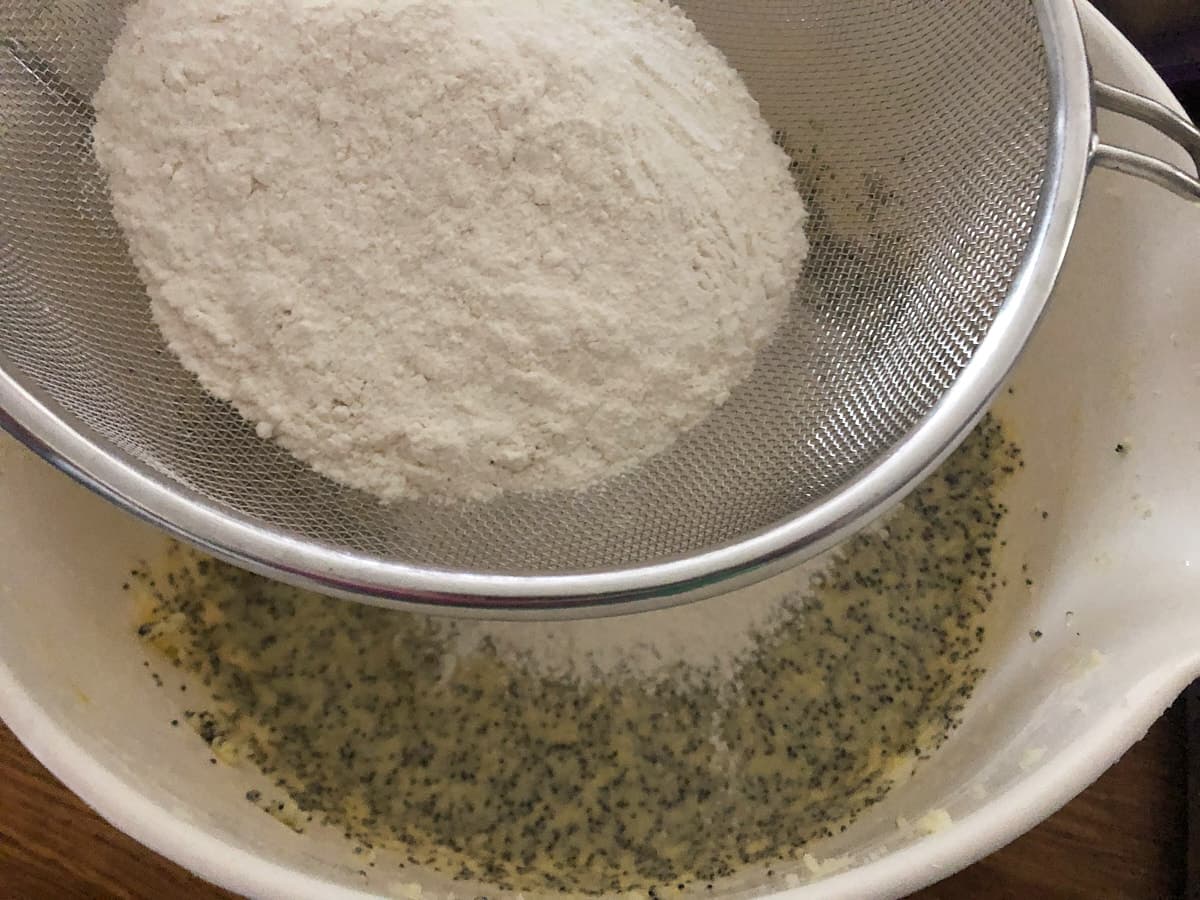 Flour being sifted into a cake batter.