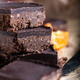 Dark chocolate orange tiffin cut into portions and stacked on a wooden board