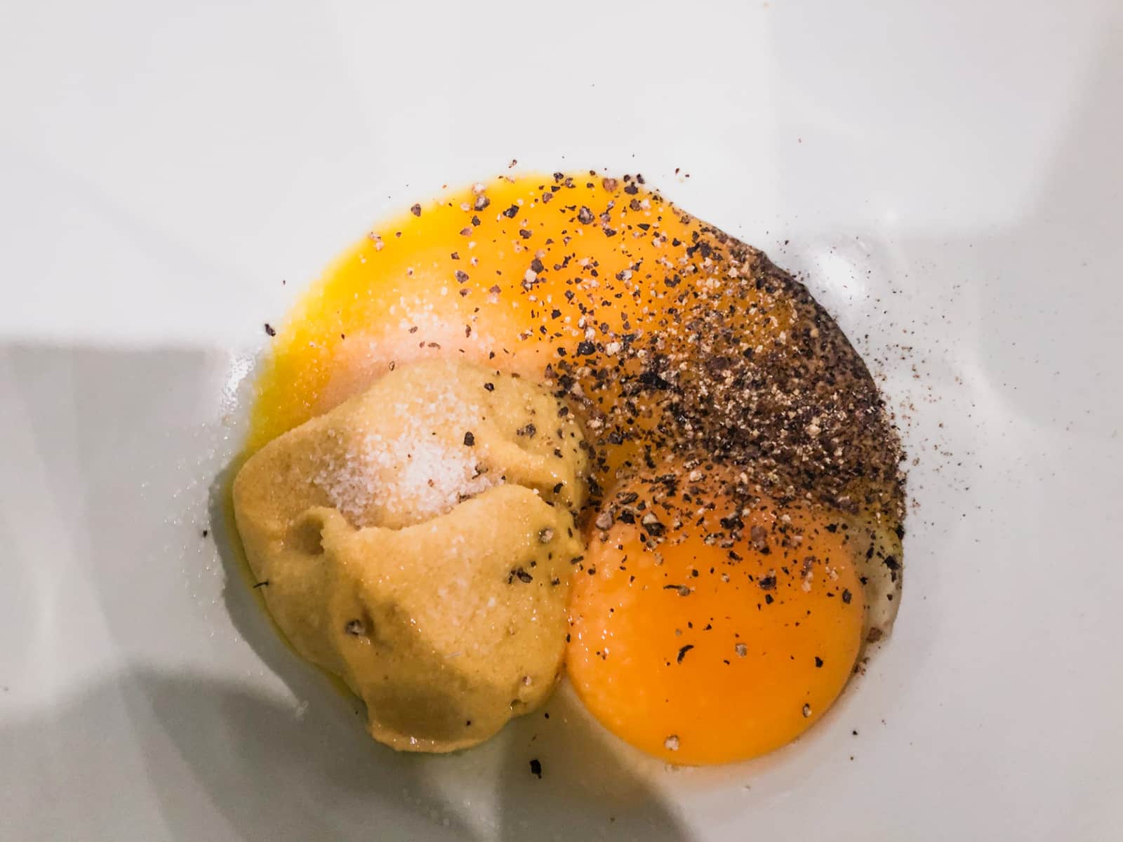 Egg yolks mixed mustard in a bowl.