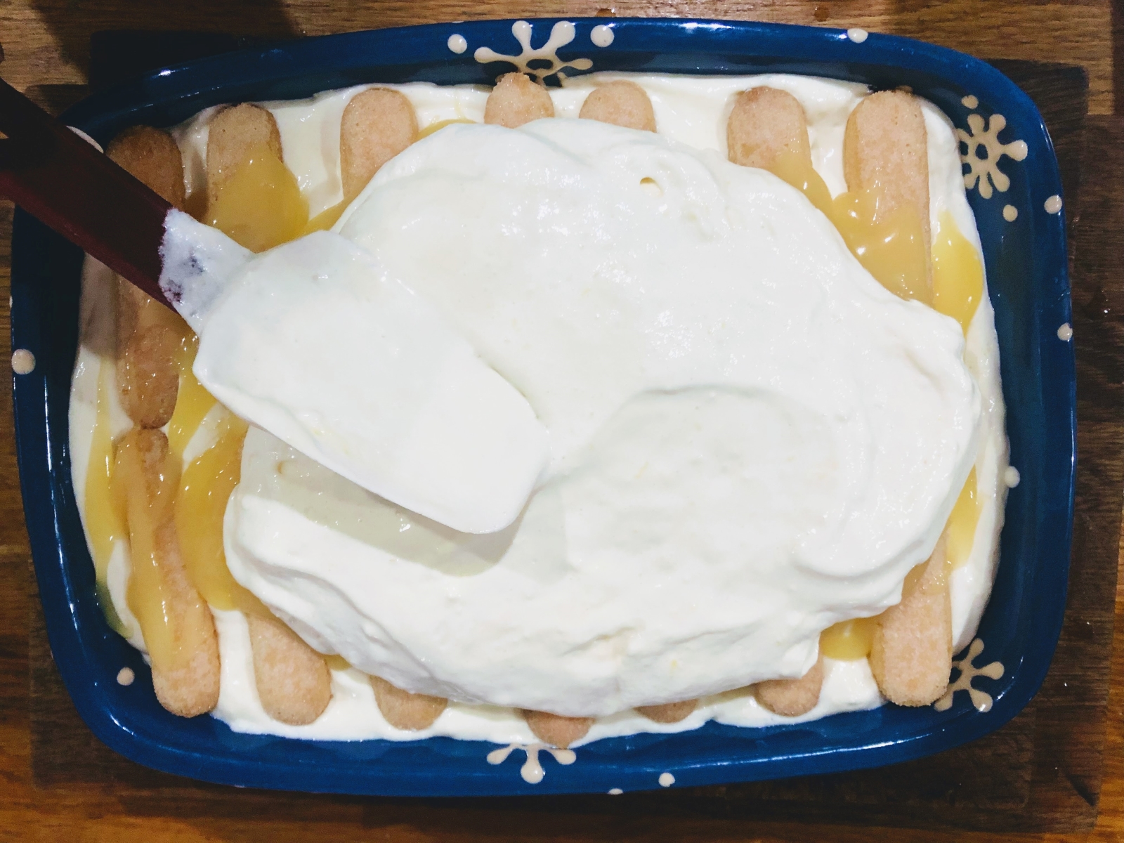 large dish with lemon tiramisu topped with final layer of lemon mascarpone cream
