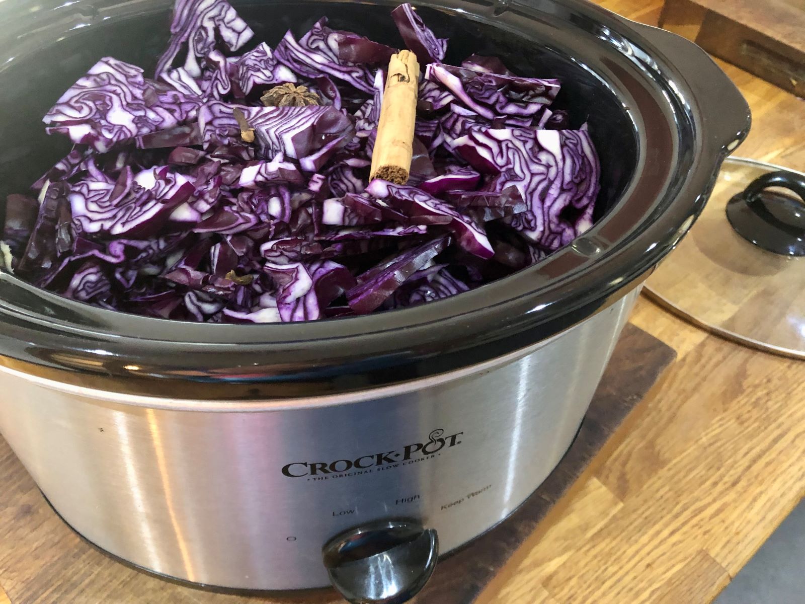 slow cooker filled with raw red cabbage and whole spices