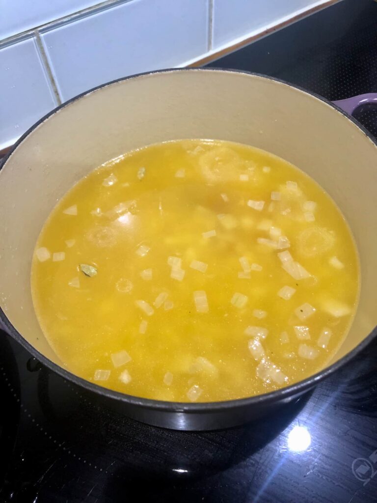 Dutch oven filled with cooked rice and a saffron broth/stock
