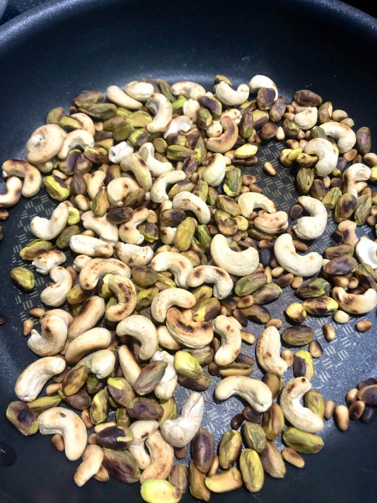 non stick pan with roasted cashew, pistachio and pine nuts