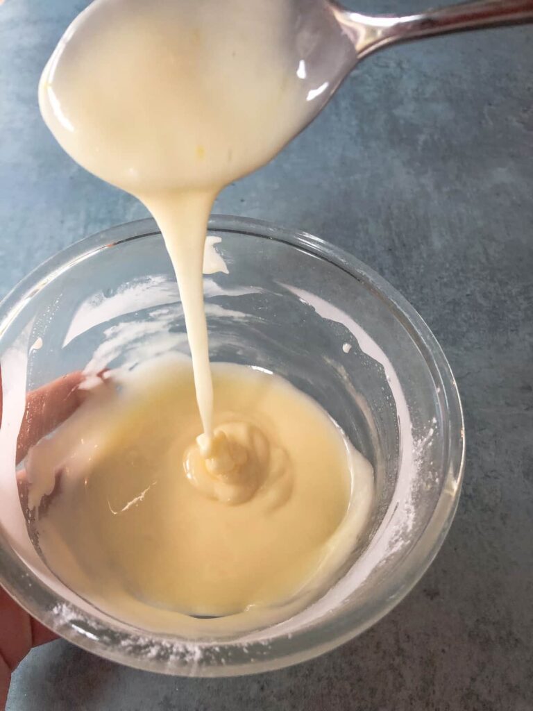 glass bowl filled with orange flavored drizzle icing