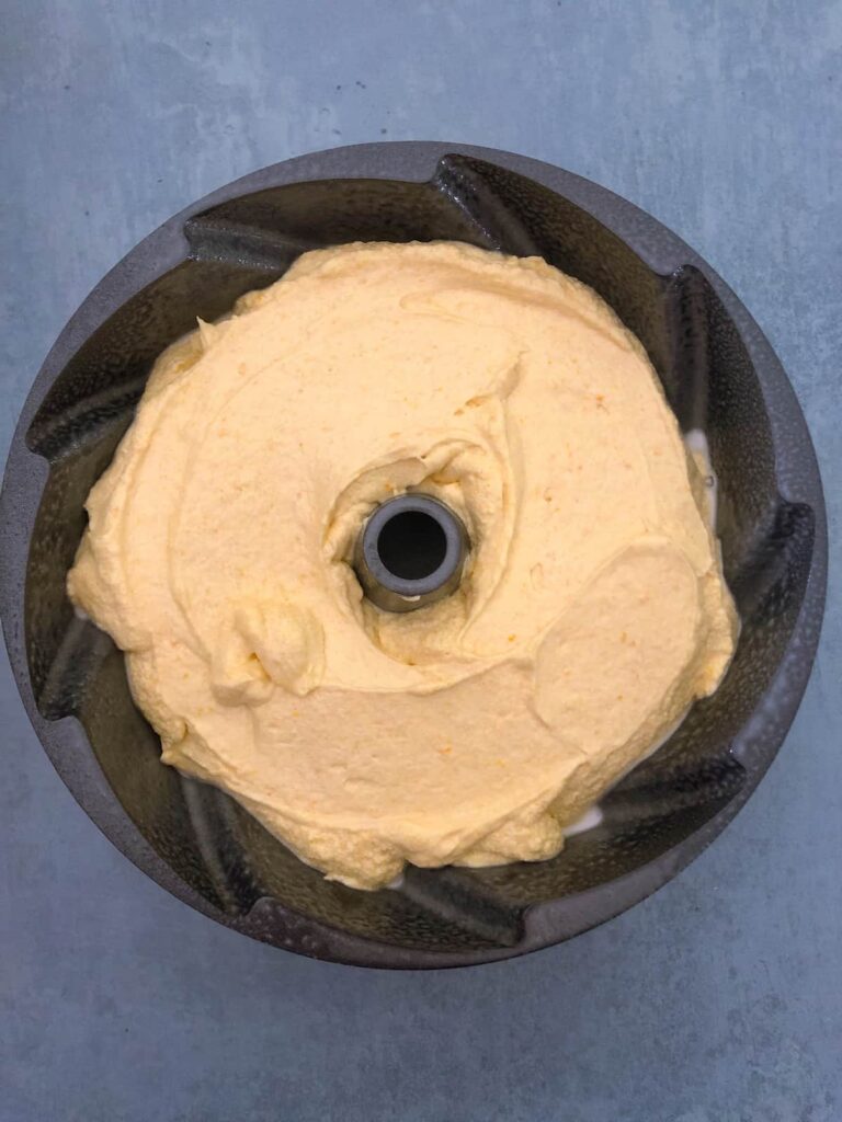 orange cake batter in a bundt tin