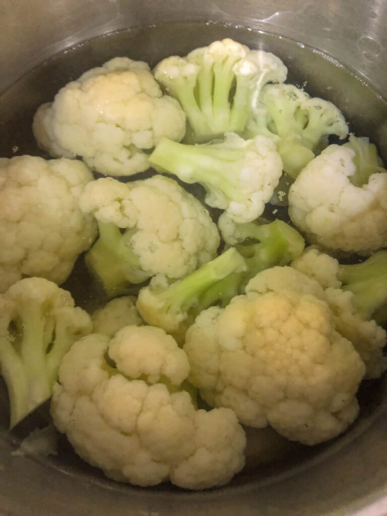 saucepan filled with cauliflower florets covered in boiling water