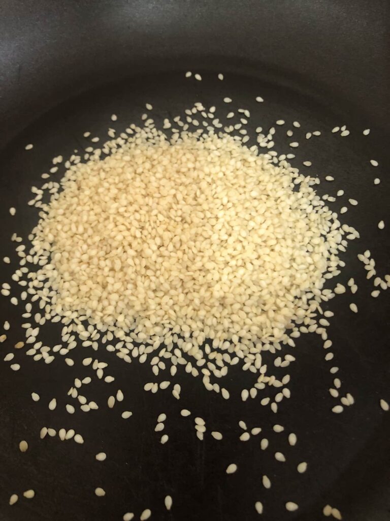 A non stick pan filled with sesame seeds.