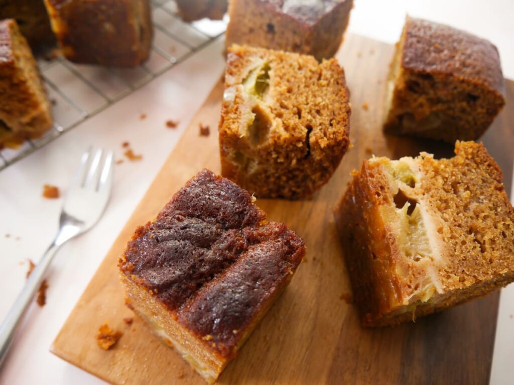 Rhubarb and ginger cake set on a wooden board.
