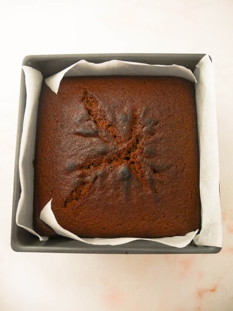 A square cake tin with a baked rhubarb and ginger cake.