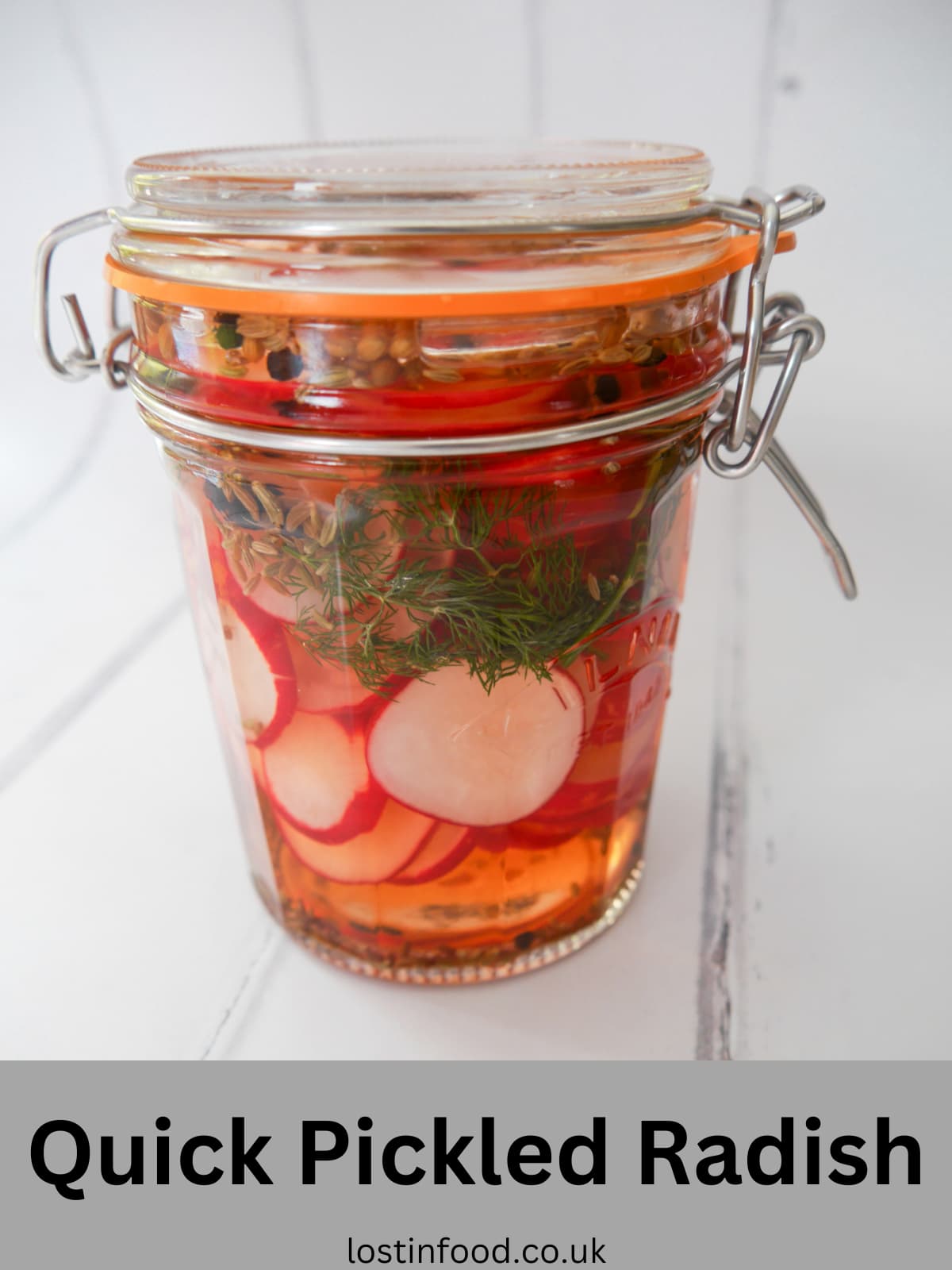 Pinnable image with recipe title and a mason jar filled with pickled radish, dill fronds and whole spices.