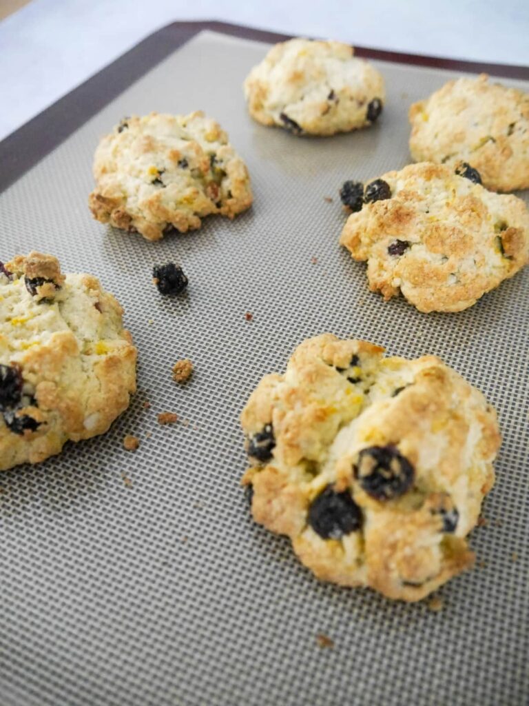 Baked rock cakes on a baking sheet lined with a silicone sheet.