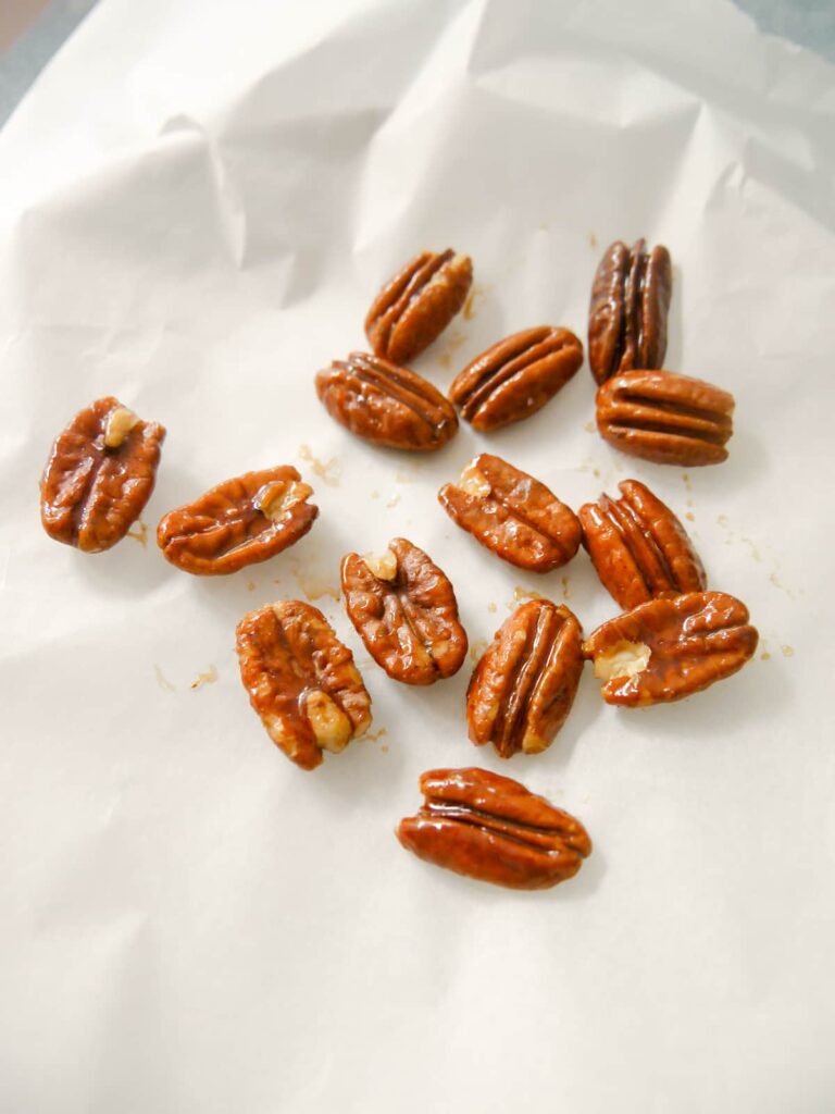 Candied pecans on a sheet of baking paper.