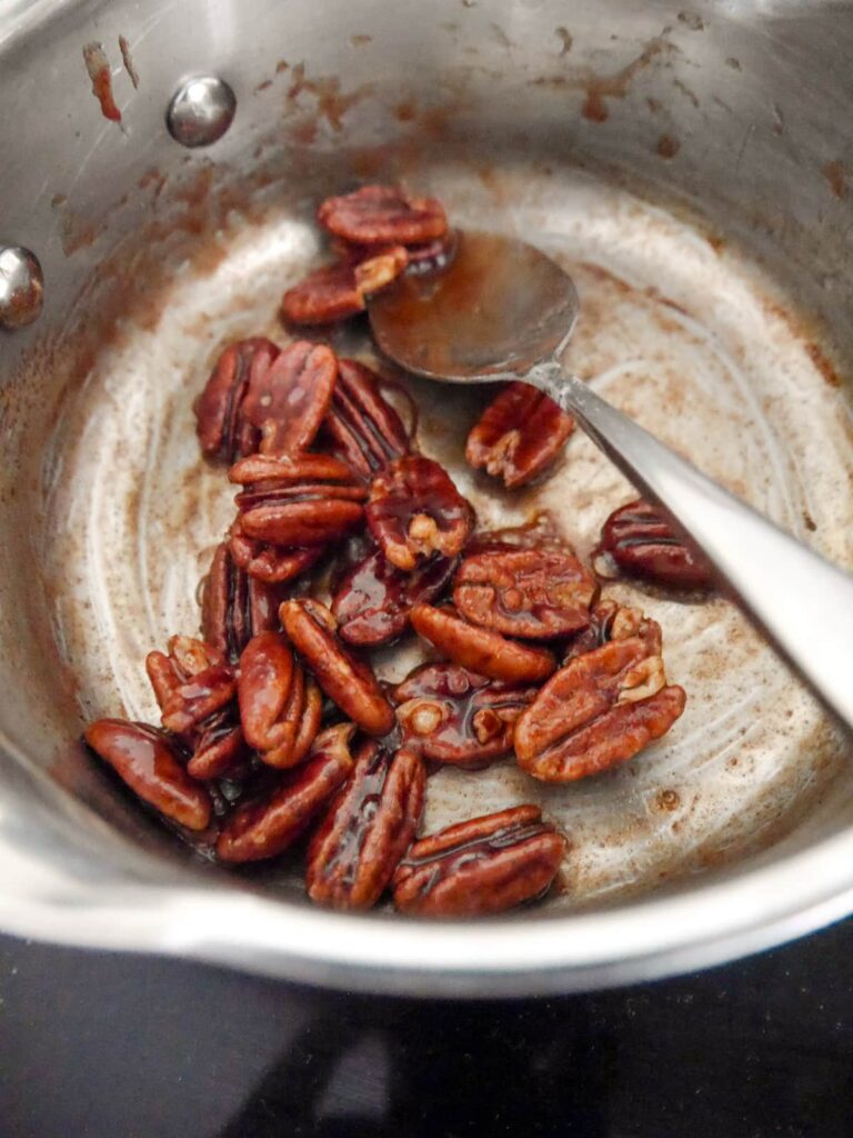 A saucepan filled with candied pecans.