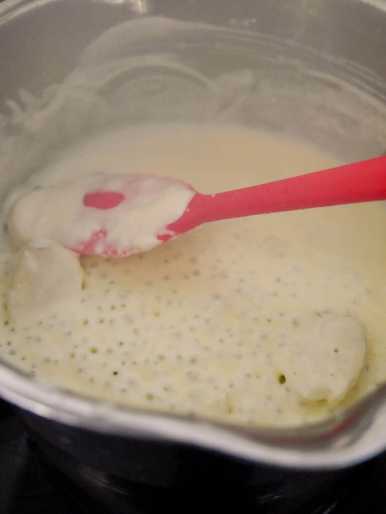 A saucepan filled with a reduction of cream.
