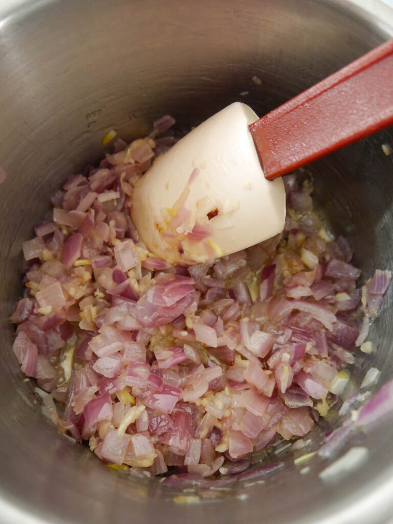 A saucepan filled with sauteed onions and garlic.