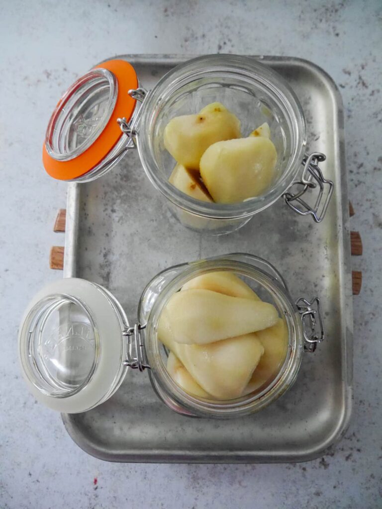 Paired pears set into 2 large glass jars.