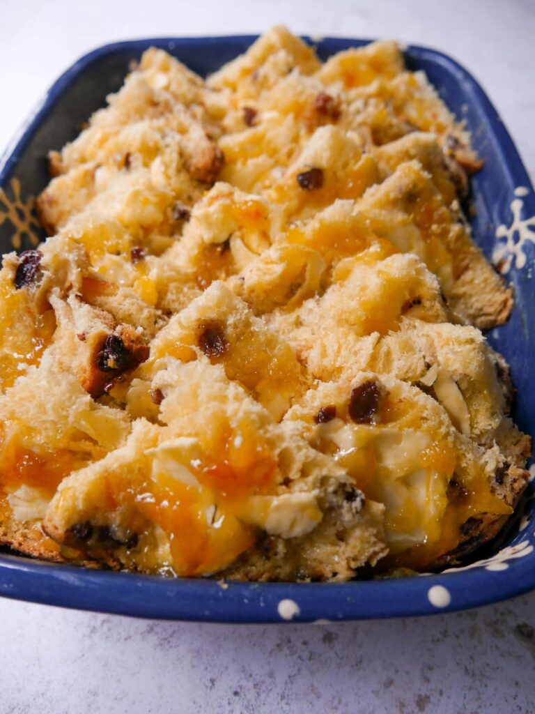 Slices of panettone spread with butter and orange marmalade layered into an oven proof dish.