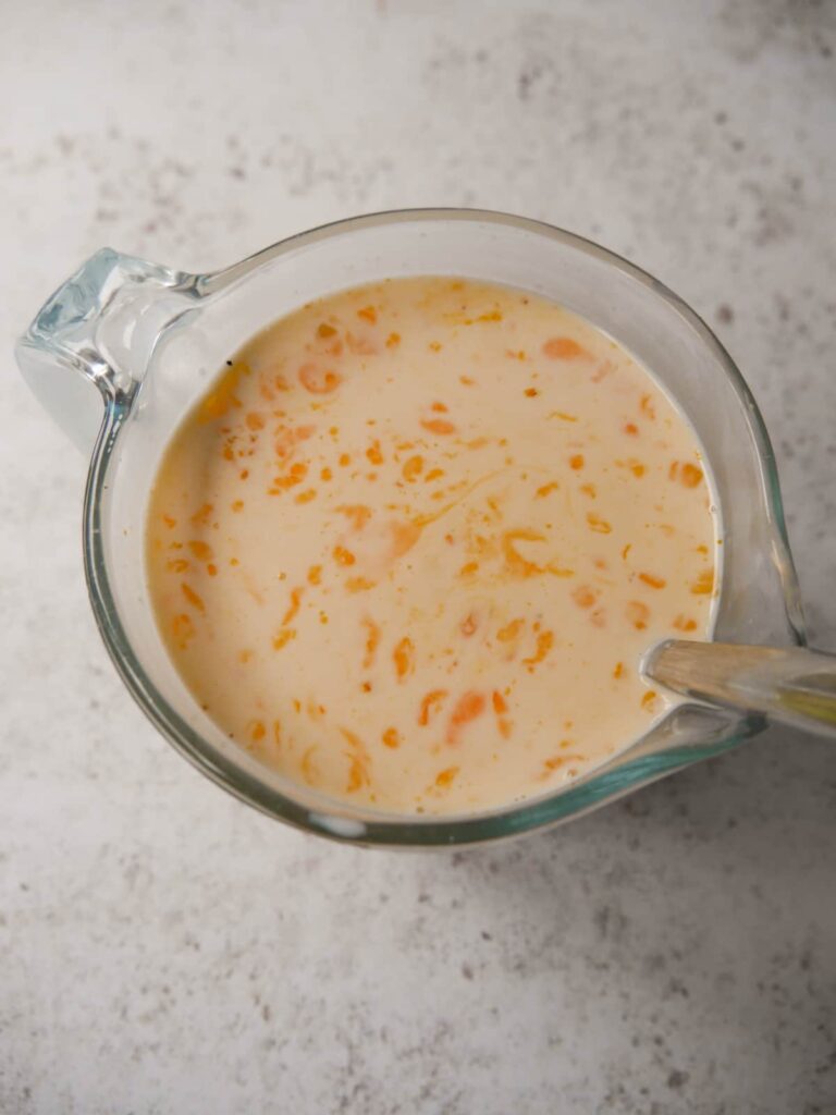 A jug filled with egg and cream pudding custard whisked together.