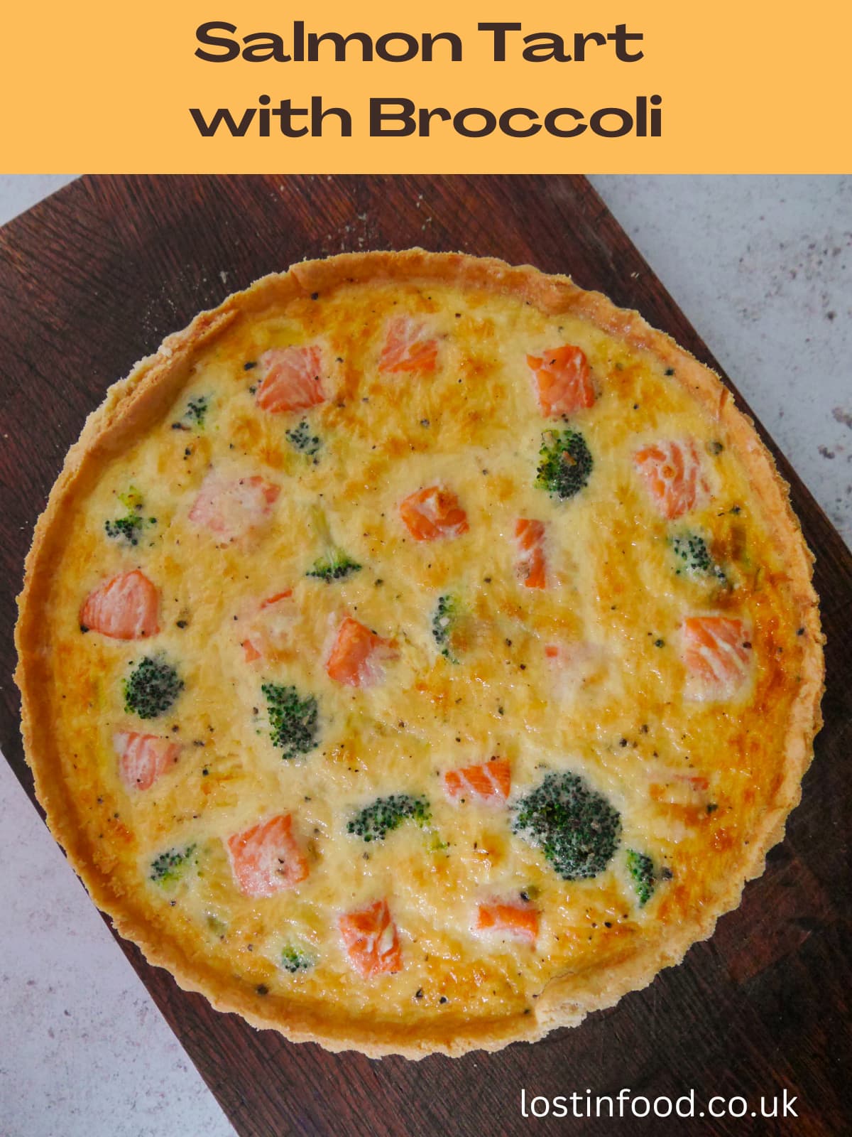 Pinnable image with recipe title and salmon tart with broccoli set on a wooden board.